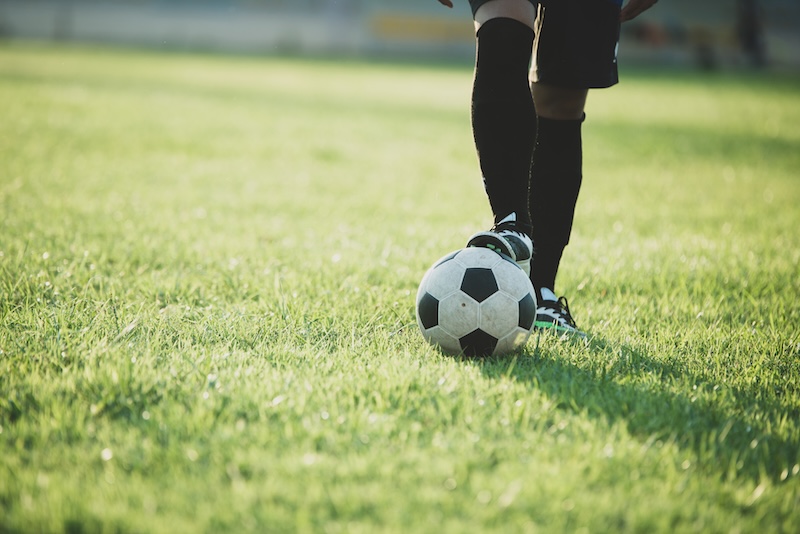 Fotbollsplan - en soelare och en boll